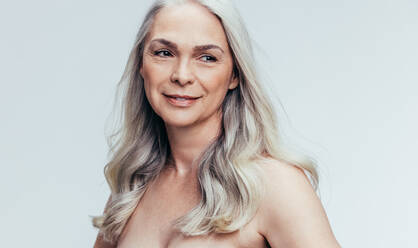 Beautiful senior woman contemplating on gray background. Sensual mature woman looking away and thinking. - JLPSF14478