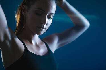 Close up of fitness female in sportswear tying her hair. Sportswoman getting ready for workout - JLPSF14570