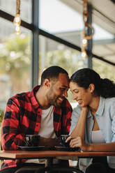 Loving couple at a coffee shop together. Smiling man and woman sitting at coffee shop. - JLPSF14659