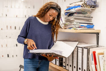 Businesswoman looking at file in office - DLTSF03294