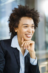 Happy businesswoman with hand on chin - DIGF19063