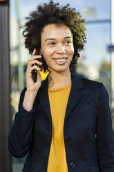 Lächelnde Geschäftsfrau, die mit einem Mobiltelefon spricht - DIGF19110