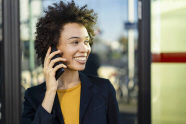 Contemplative businesswoman communicating through mobile phone - DIGF19111