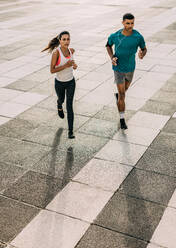 Paar in Sportkleidung beim gemeinsamen Training in der Stadt. Sportlicher Mann und Frau beim gemeinsamen Laufen in der Stadt. - JLPSF14762