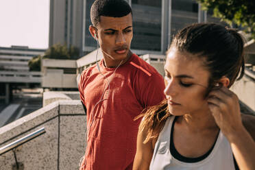 Fitness couple out in the city for morning workout routine. Man and woman in sportswear getting ready for a morning run. - JLPSF14767