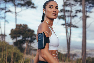 Sportliche Frau mit Smartphone-Armband beim morgendlichen Spaziergang im Freien. Fitness-Frau beim morgendlichen Training. - JLPSF14922