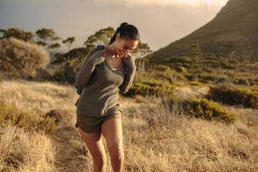 Happy woman walking down the country trail. Young female enjoying hiking in nature. - JLPSF14959