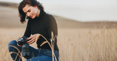 Frau prüft Bilder auf professioneller Digitalkamera. Profi-Fotograf im Freien mit einer Spiegelreflexkamera. - JLPSF15069