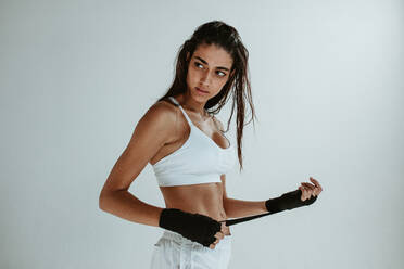 Fitness Frau trägt Hand Wraps für das Training. Fitness weibliche immer bereit für körperliche Ausbildung gegen weißen Hintergrund. - JLPSF15129