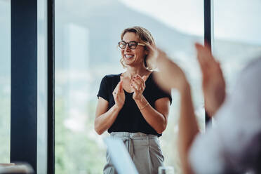 Businesswoman clapping hands after successful brainstorming session in boardroom. Business people women applauding after productive meeting. - JLPSF15133