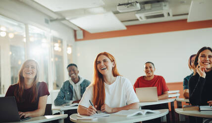 Gruppe von Teenager-Studenten lächelnd während der Vorlesung im Klassenzimmer. Universität Studenten lachen im Klassenzimmer. - JLPSF15139