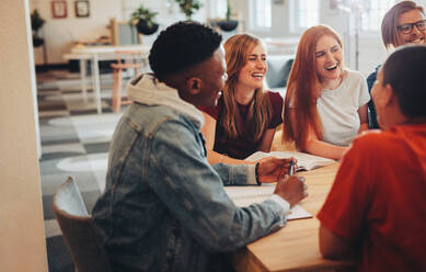 Gruppe multiethnischer Studenten in einem Klassenzimmer. Studiengruppe sitzt am Tisch und lächelt in der Universität. - JLPSF15148