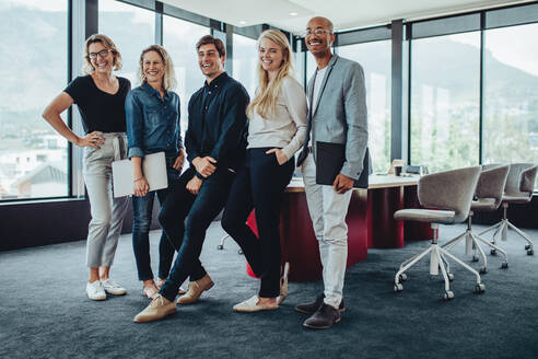 Eine Gruppe von Geschäftsleuten steht in einem Sitzungssaal zusammen. Eine Gruppe von Fachleuten nach einer Sitzung im Büro. - JLPSF15222