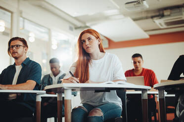 Hübsche Teenager-Studentin, die im Klassenzimmer der Vorlesung Aufmerksamkeit schenkt. Frau, die im Klassenzimmer der Hochschule studiert. - JLPSF15367