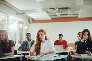 Jugendlicher Student, der in der Vorlesung aufmerksam zuhört. Frau, die im Klassenzimmer der Universität lernt. - JLPSF15373