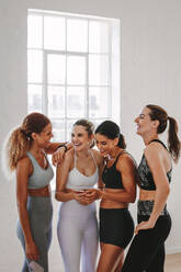 Fitness-Frauen im Fitness-Studio mit Online-Workout-App. Gruppe von sportlichen Frauen über das Training mit Training App auf dem Smartphone. - JLPSF15434