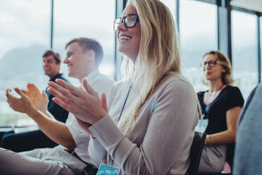 Eine Gruppe von Geschäftsleuten klatscht bei einem Seminar in die Hände. Geschäftsleute, die an einer Konferenz teilnehmen, klatschen in die Hände. - JLPSF15457