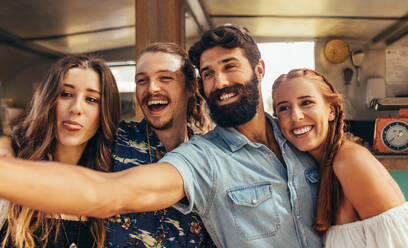 Happy young guy with friends taking a selfie. Group of friends making selfie at outdoors. - JLPSF15661