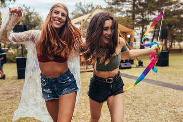 Hipster-Mädchen, die sich auf einem Musikfestival im Freien amüsieren. Zwei Frauen, die sich im Park während eines Sommerfestivals vergnügen. - JLPSF15688