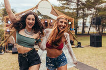 Foto de Enjoying the festival vibe. Two mature woman sitting outdoors at a  music festival. do Stock