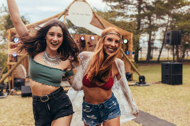 Two cool girls are having fun at music festival at park. Women friends in summer wear enjoying at music festival. - JLPSF15690