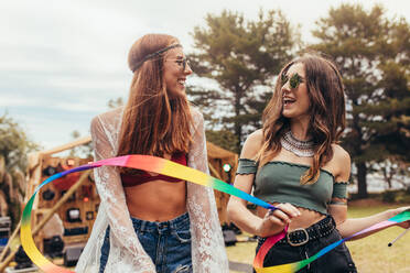 Hipsters with dancing ribbon stick at music festival. Two young women enjoying at music festival. - JLPSF15692