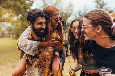 Gruppe von Männern und Frauen auf einem Musikfestival. Freunde, die sich auf einem Musikfestival in einem Park amüsieren. - JLPSF15696