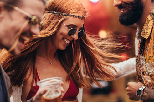 Hippie-Mädchen tanzt mit einer Gruppe von Freunden auf einem Musikfestival. Junge Leute haben viel Spaß auf einem Musikfestival. - JLPSF15710