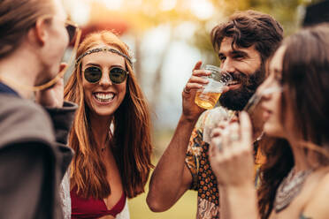 Friends enjoying at music festival with drinks. Young people enjoying at summer music festival. - JLPSF15715