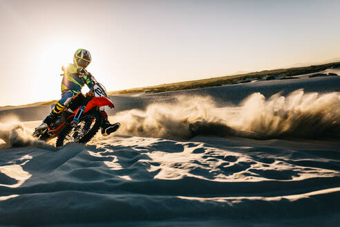 Motorradfahrer fährt Dirt Bike in der Wüste. Motocross-Fahrer in Aktion auf Sanddünen. - JLPSF15876