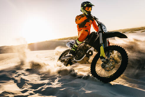 Männlicher Biker fährt Dirt Bike auf dem Sand in der Wüste. Motocross Off-Road auf Sanddünen. - JLPSF15977