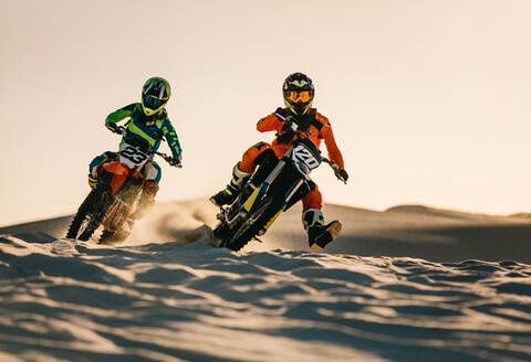 Zwei Dirt-Biker fahren ein Rennen auf einer Sanddüne, ein Offroad-Wettbewerb in der Wüste. - JLPSF15980