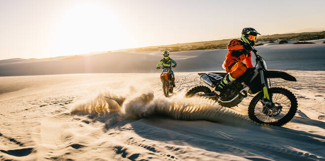 Zwei Motocross-Fahrer fahren Dirt-Bikes in der Wüste. Professionelle Dirt-Biker im Gelände auf Sanddünen. - JLPSF16018