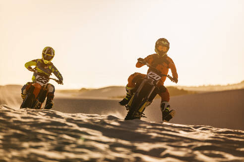 Zwei Motocross-Rennfahrer auf der Off-Road-Strecke, professionelle Dirt-Biker bei einem Rennen in den Sanddünen. - JLPSF16023