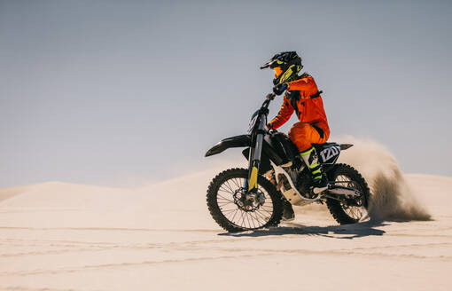 Motocross-Rennfahrer fahren über Sand in der Wüste. Motocross-Biker fahren Motorrad über Sanddünen. - JLPSF16044