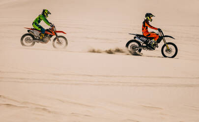 Motocross enduro riders in action accelerating the motorbike in desert. Extreme off-road race. - JLPSF16048