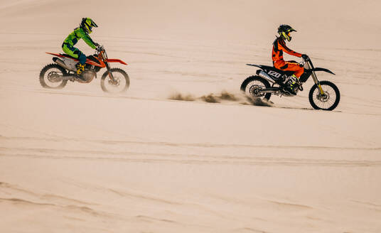 Motocross-Enduro-Fahrer in Aktion beim Beschleunigen des Motorrads in der Wüste. Extremes Offroad-Rennen. - JLPSF16048