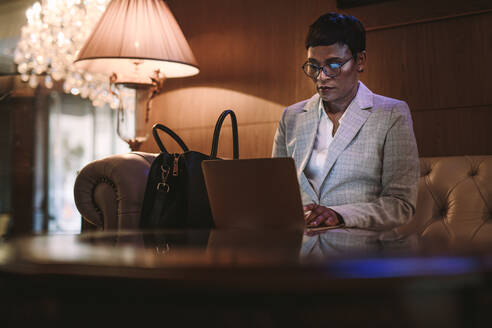 Reife afrikanische Frau sitzt an der Hotelrezeption und arbeitet am Laptop. Weiblicher CEO auf Geschäftsreise benutzt Laptop in der Hotellobby. - JLPSF16142