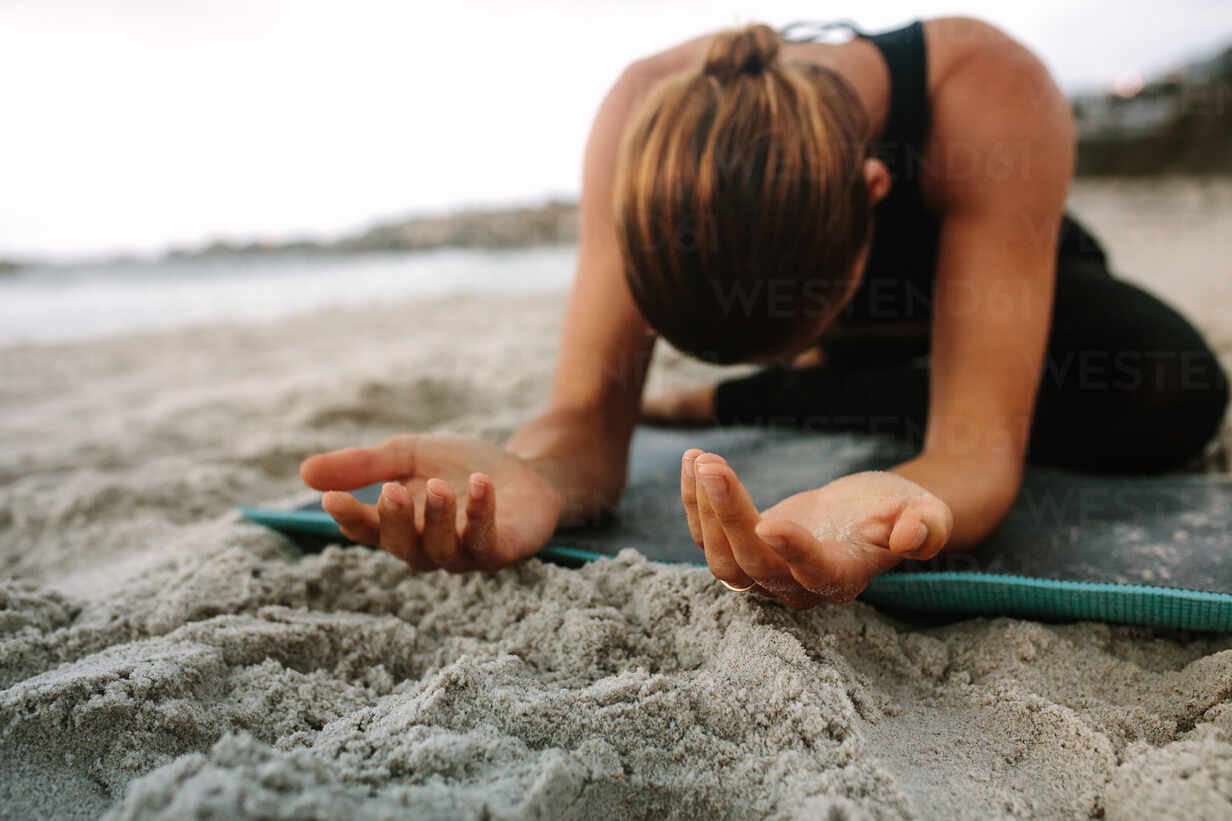 Sports woman doing yoga along the beach – Jacob Lund Photography