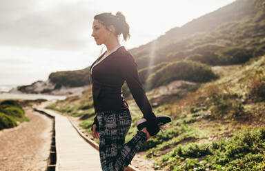 Fitness-Frau dehnt ihr Bein nach einem Lauf. Läuferin beim Stretching-Training im Freien. - JLPSF16244