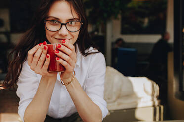 Schöne junge Frau mit einer Tasse Kaffee im Café. Geschäftsfrau im Café beim Kaffee trinken. - JLPSF16493