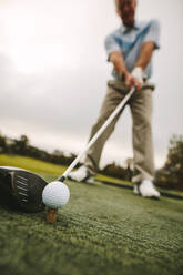 Golfschläger und Golfball auf grünem Gras, bereit zum Spielen. Männlicher Golfer, der einen Schlag auf dem Golfplatz macht. - JLPSF16499