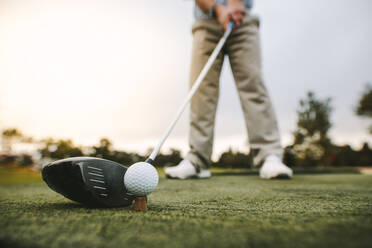 Golfschläger und Golfball auf dem Abschlag auf der Driving Range. Konzentrieren Sie sich auf den Kopf des Schlägers und den Ball. - JLPSF16670