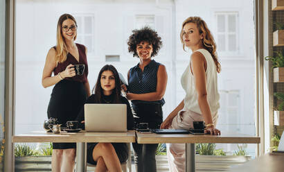 Porträt von vier erfolgreichen jungen Geschäftsfrauen in einem Büro. Gruppe multiethnischer Geschäftsfrauen schaut in die Kamera. - JLPSF16773