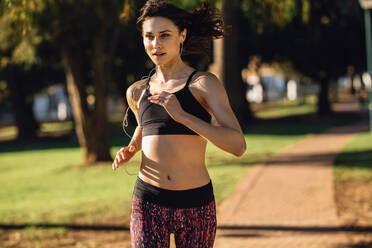 Side view of woman jogging at park stock photo