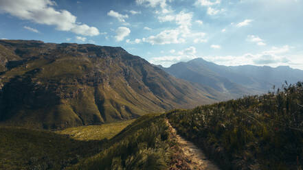 Beautiful mountain range with cloudy sky in Jonkershoek nature reserve. Footpath over green mountain. - JLPSF16951