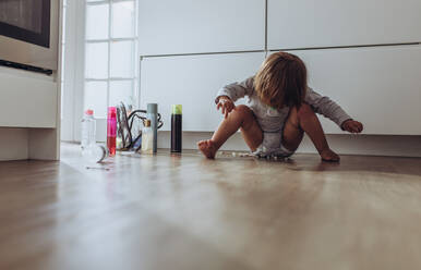 Kid playing at home with household articles. Kid playing alone at home sitting on the floor. - JLPSF17021