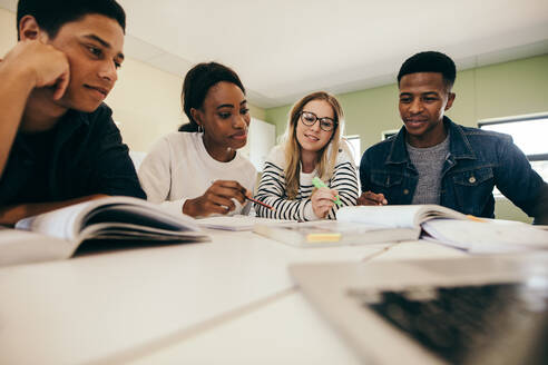 Eine Gruppe multiethnischer Studenten in einem Klassenzimmer. Studenten lernen mit Büchern in der Universität. - JLPSF17127