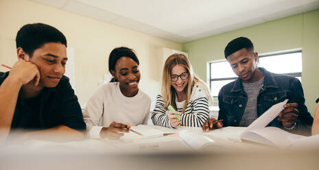 Verschiedene Gruppen von Studenten mit Büchern, die sich in einem Klassenzimmer auf eine Prüfung vorbereiten. Gruppe von Jungen und Mädchen, die mit Büchern lernen. - JLPSF17128