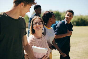 Gruppe von Universitätsstudenten auf dem Campus. Multiethnische Studenten gehen gemeinsam im Freien. - JLPSF17157